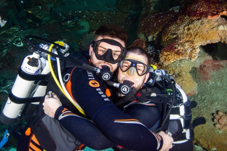 Scuba Divers hugging underwater