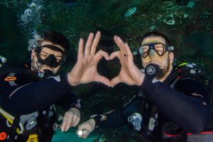 Divers making a heart with their hands
